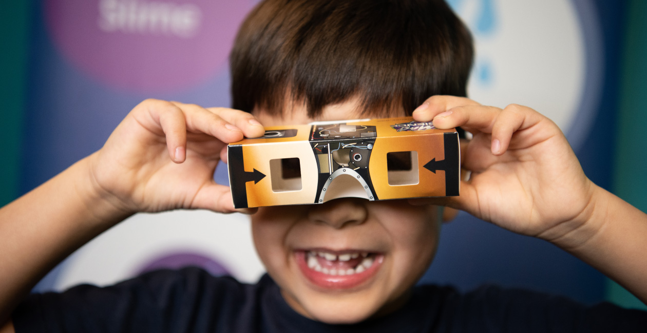 A boy playing with our Stereoscopic Viewer take-home from our NASA Academy of Future Space Explorers program.